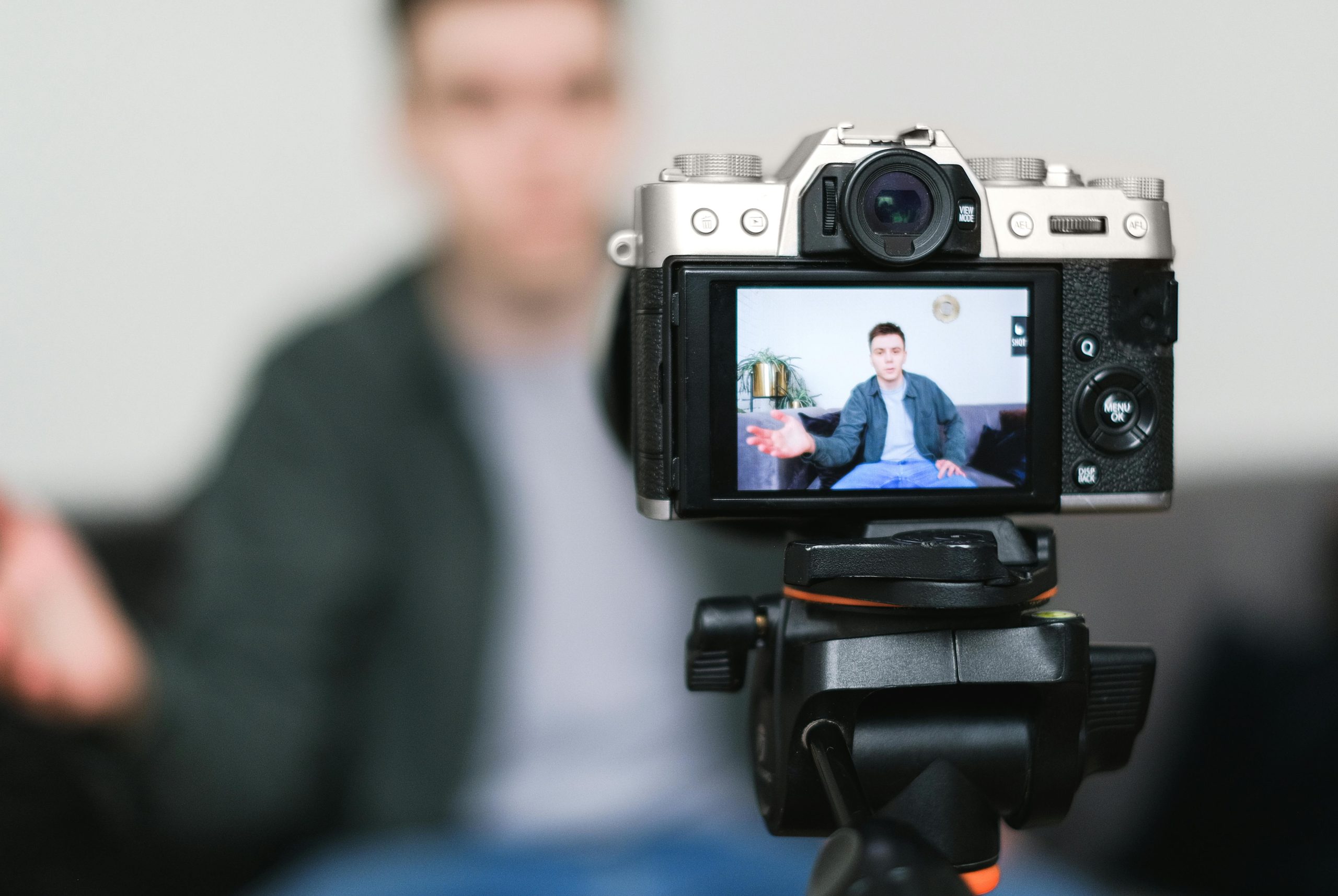Appareil photo sur trépied filmant une personne assise pour un vlog à la maison