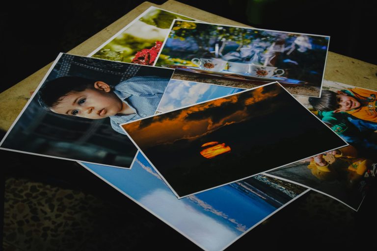 Plusieurs tirages photo imprimés posés sur une table, illustrant l’intérêt d’imprimer ses photos plutôt que de les laisser sur écran.