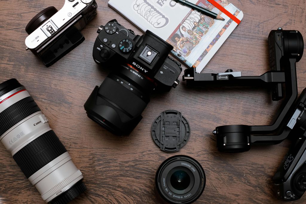 Matériel photo avec boîtier hybride, objectifs et accessoires sur une table en bois