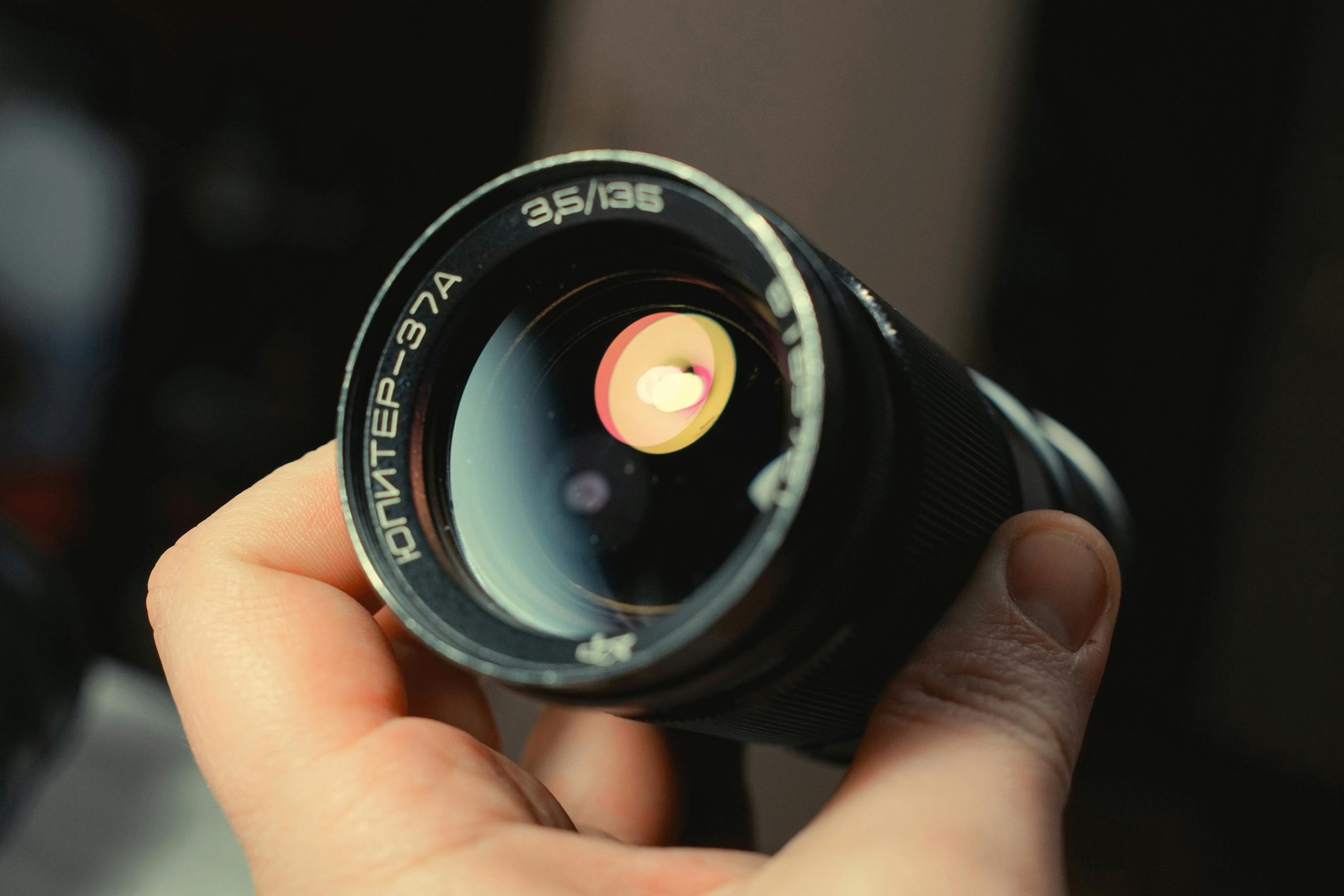 Objectif vintage soviétique Jupiter-37A 135 mm tenu en main, gros plan sur la lentille frontale