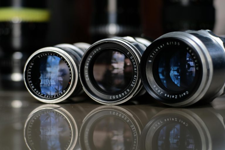 Trois objectifs vintage Carl Zeiss Jena et Triotar alignés sur une table, en gros plan