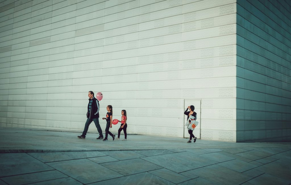 Scène urbaine minimaliste avec passants devant une grande façade moderne