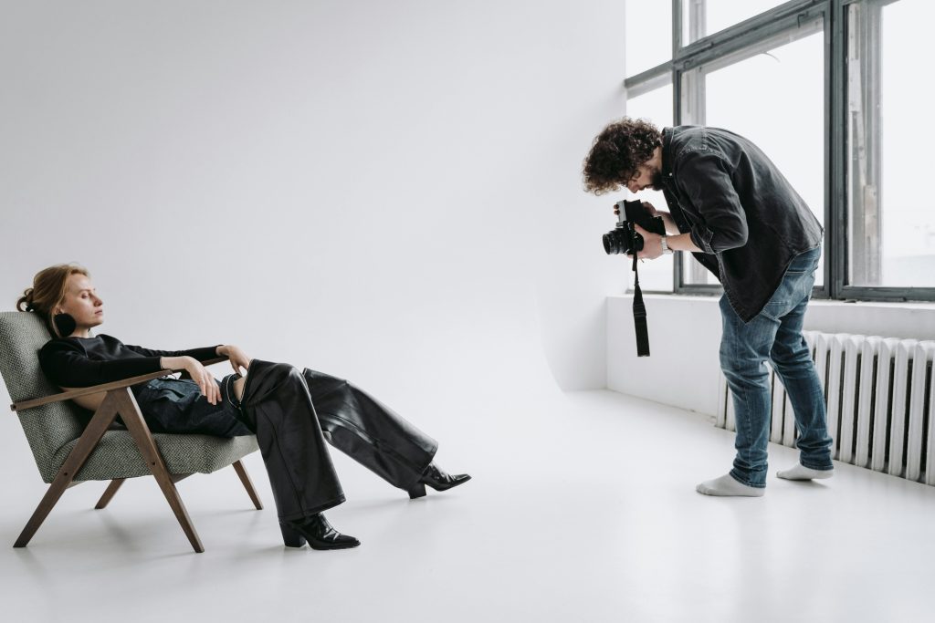 Photographe en train de cadrer un portrait dans un studio lumineux