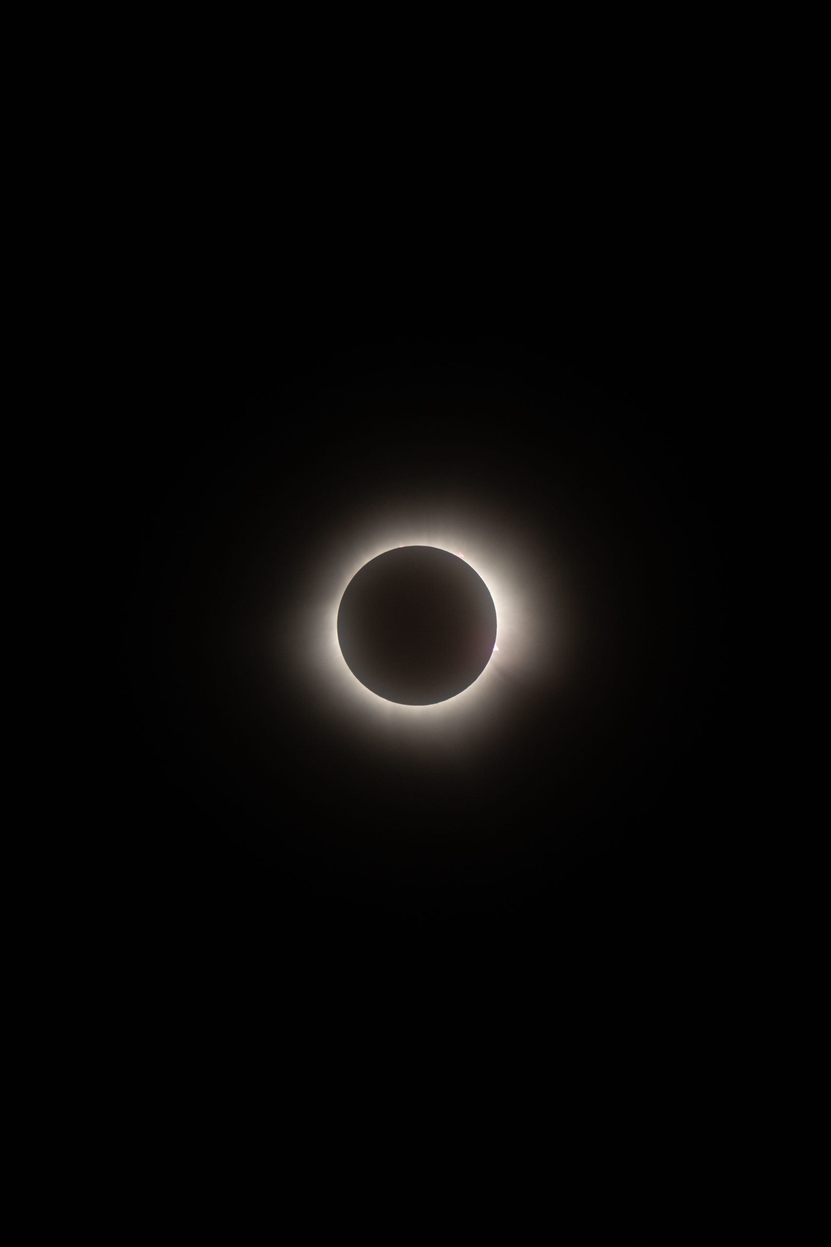 Éclipse solaire totale avec couronne lumineuse sur fond de ciel noir