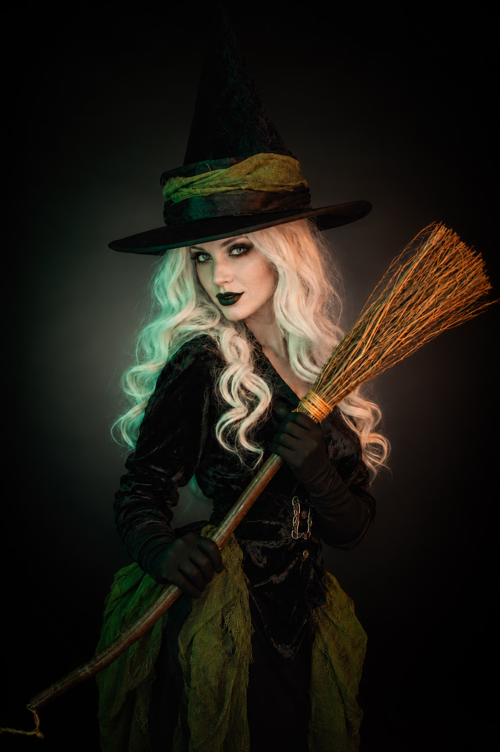 Portrait de sorcière avec chapeau et balai réalisé en studio pour Halloween